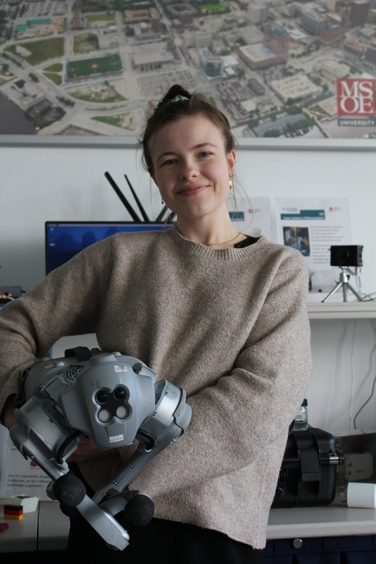 HL4_KI-Standort LübeckFinja Wegener, wissenschaftliche Mitarbeiterin an der Technischen Hochschule Lübeck, mit einem humanoiden RoboterIMG_7943