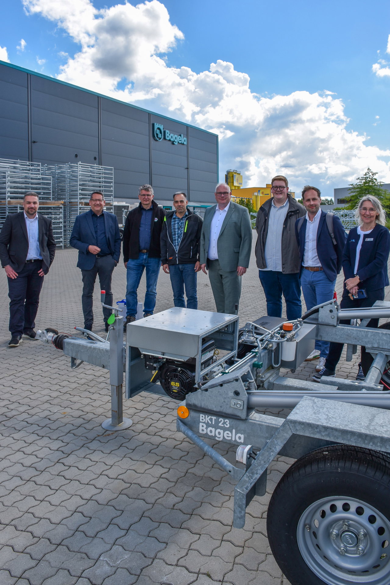 Gruppenbild neben einem Maschinenanhänger der Bagela Baumaschinen GmbH