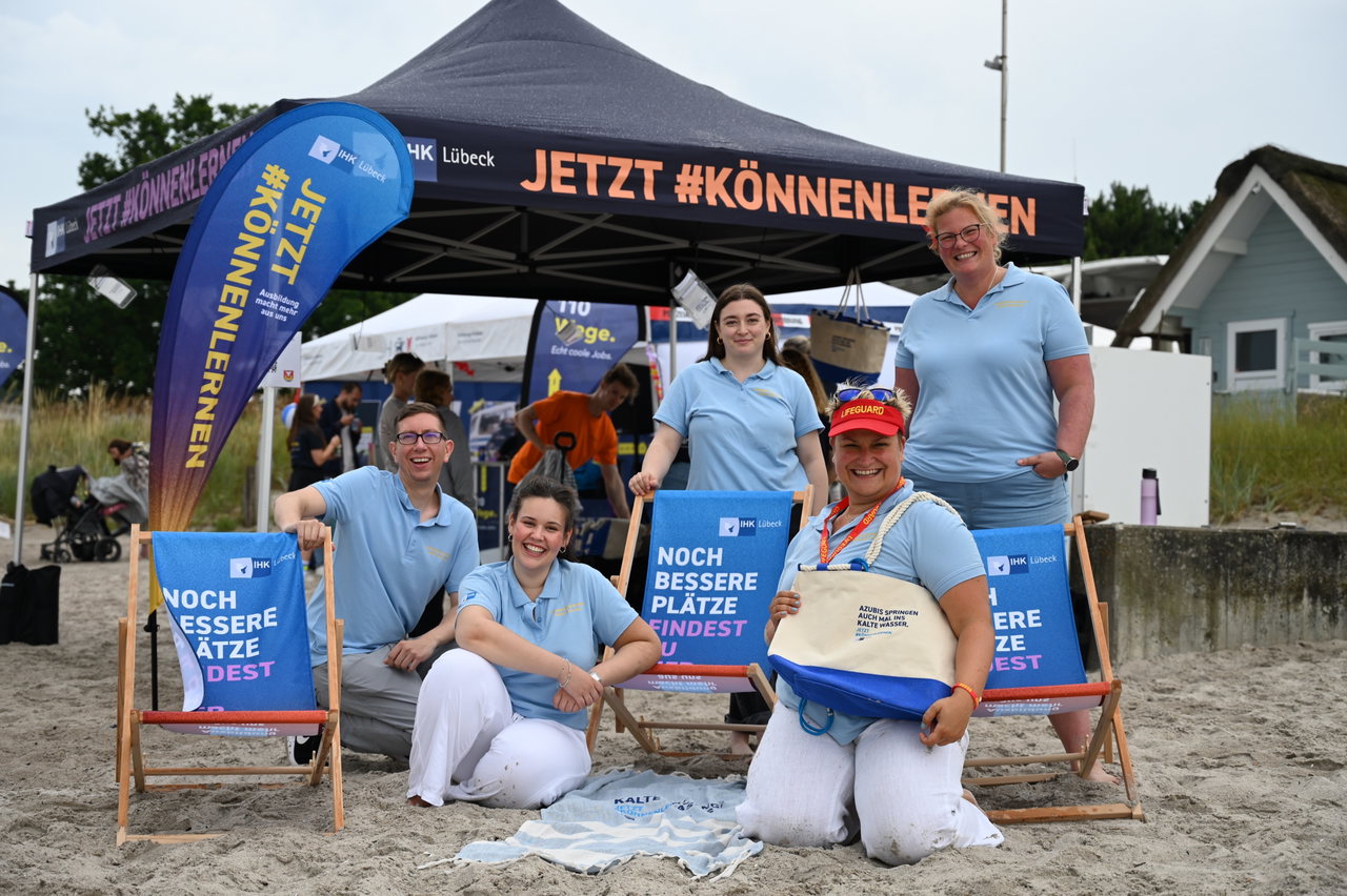 Polizei-Team in hellblauen Poloshirts auf Liegestühlen am Strand vor dem Zelt „JETZT #KÖNNENLERNEN“