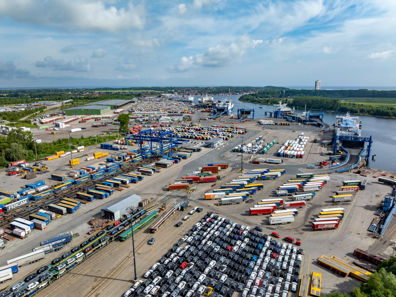 Luftaufnahme des Skandinavienkais im Lübecker Hafen mit Fähren, Trailern, Neuwagen und Gleisanlagen