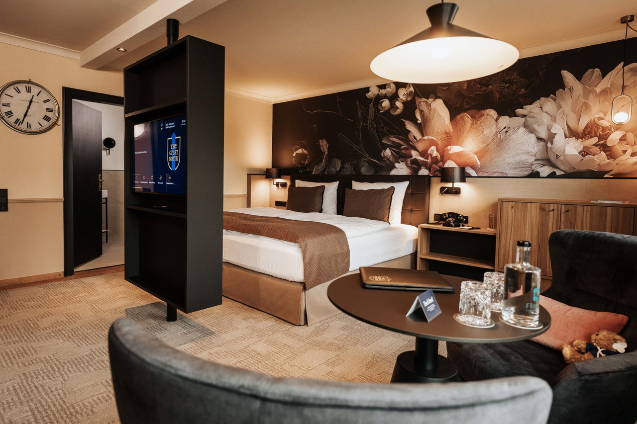 Modern eingerichtetes Hotelzimmer im The Great North mit Doppelbett, Sitzecke und Fernseher