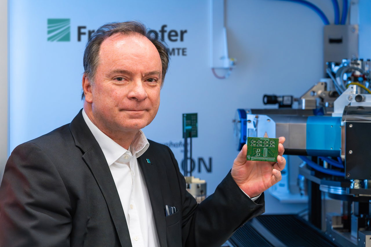 Professor Dr. Thorsten M. Buzug hält eine Leiterplatte vor die CT-Anlage im Prüflabor des Fraunhofer IMTE
