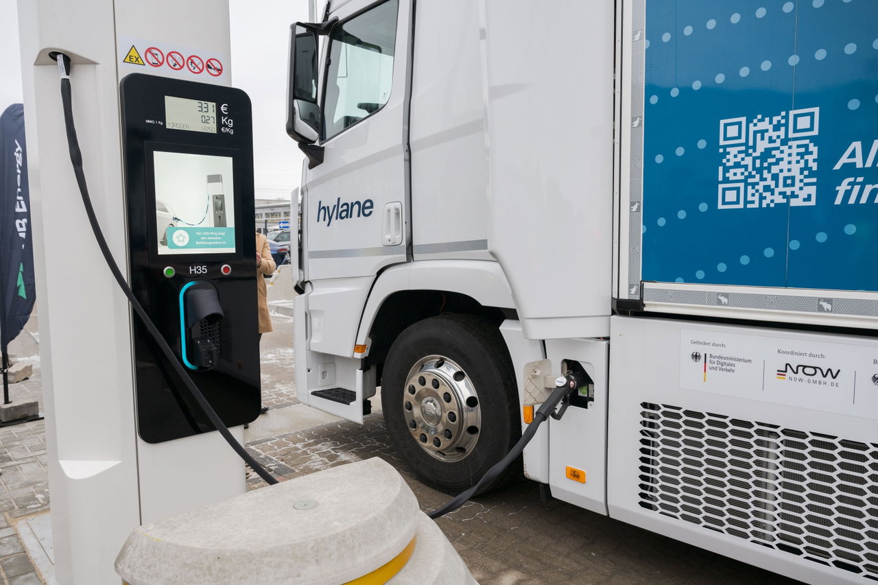 Wasserstoff-Lkw an einer Zapfsäule, der Tankschlauch steckt im Tankstutzen