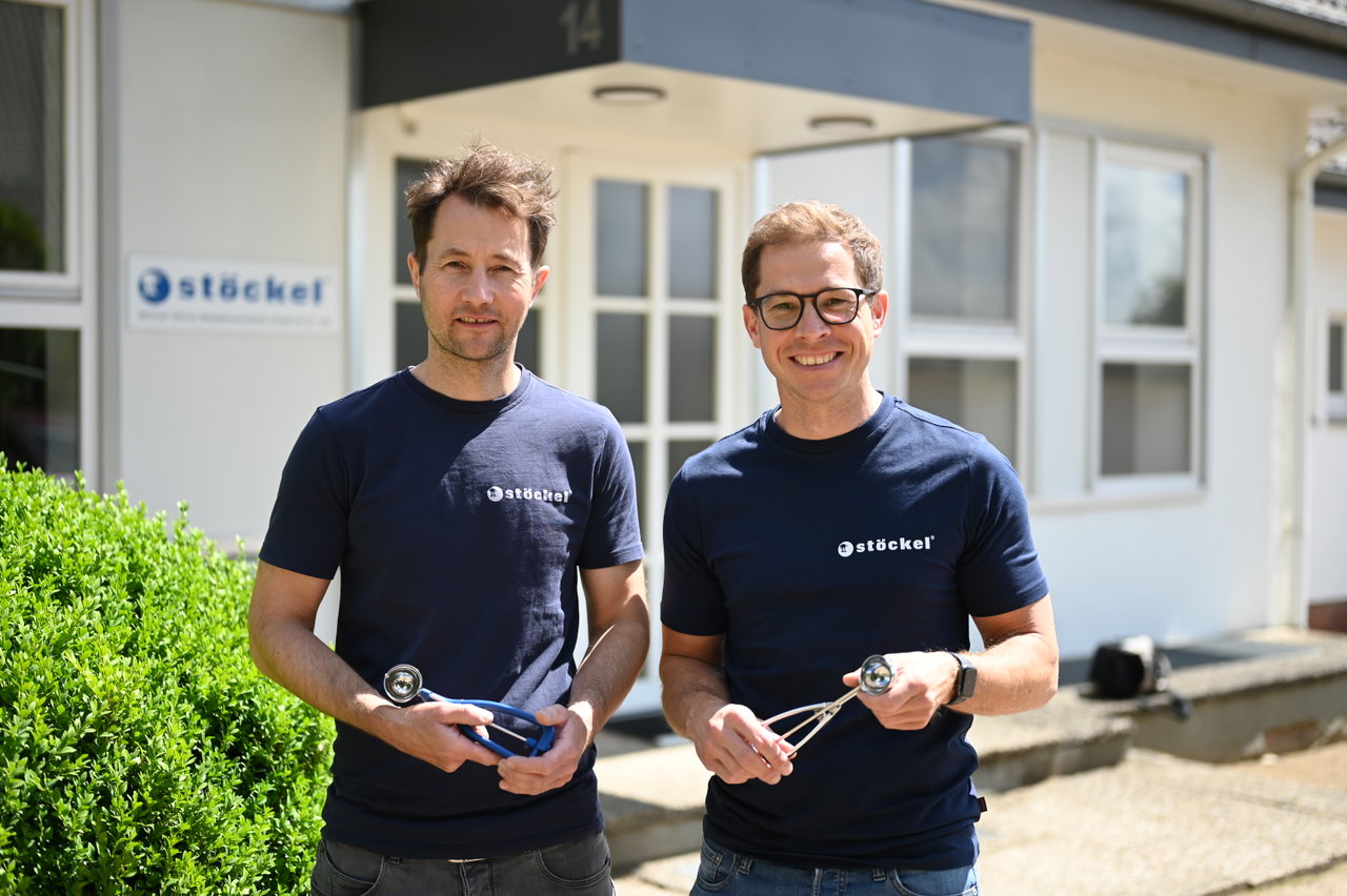 Zwei Mitarbeiter der Stöckel Söhne Metallwarenfabrik vor dem Betriebsgebäude