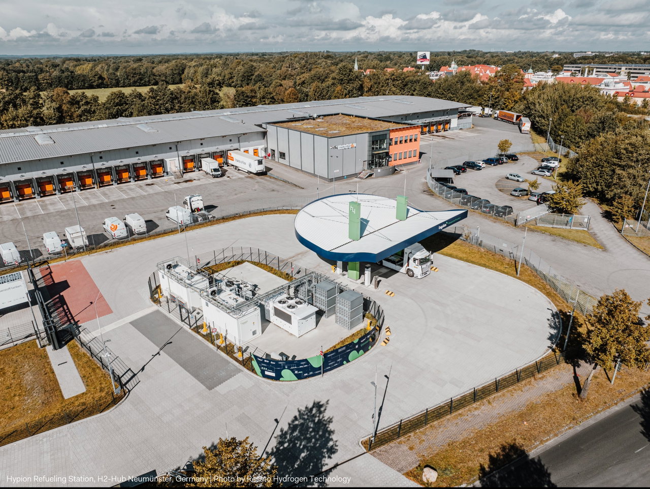 Luftaufnahme der Wasserstofftankstelle der MB Energy Gruppe in Neumünster mit Überdachung, Technikanlagen und Lagerhallen