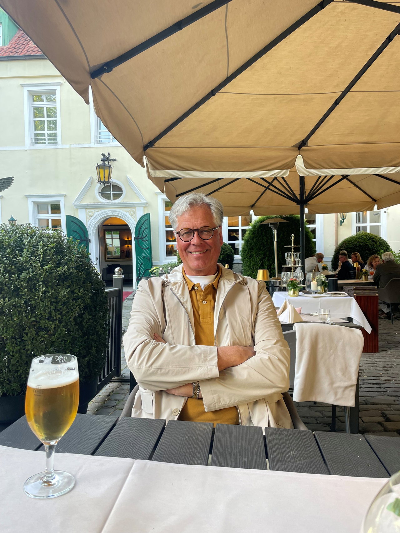 Lambertus Muller unter der Markise der Terrassengastronomie, davor ein Glas Bier
