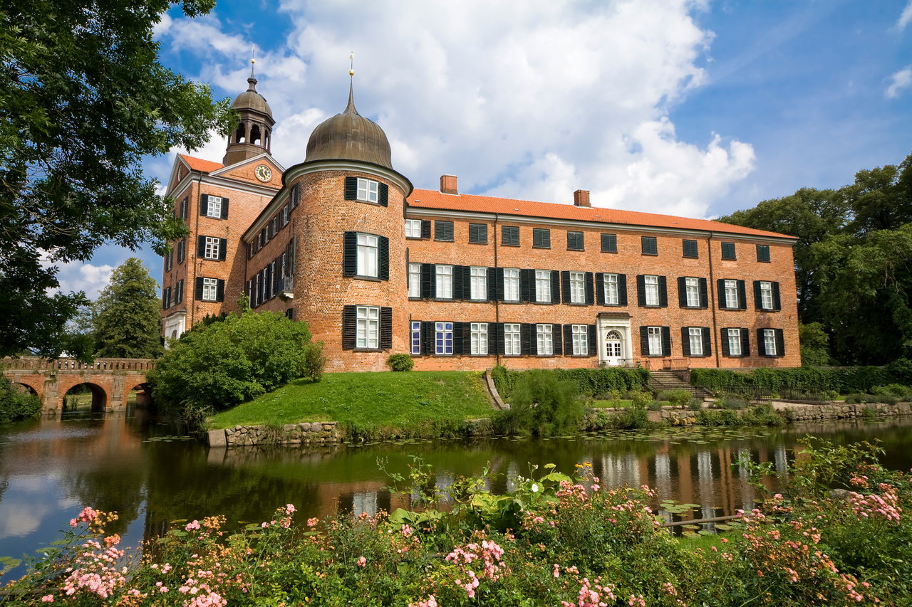 Schloss Eutin am Wasser mit Brücke und blühenden Beeten