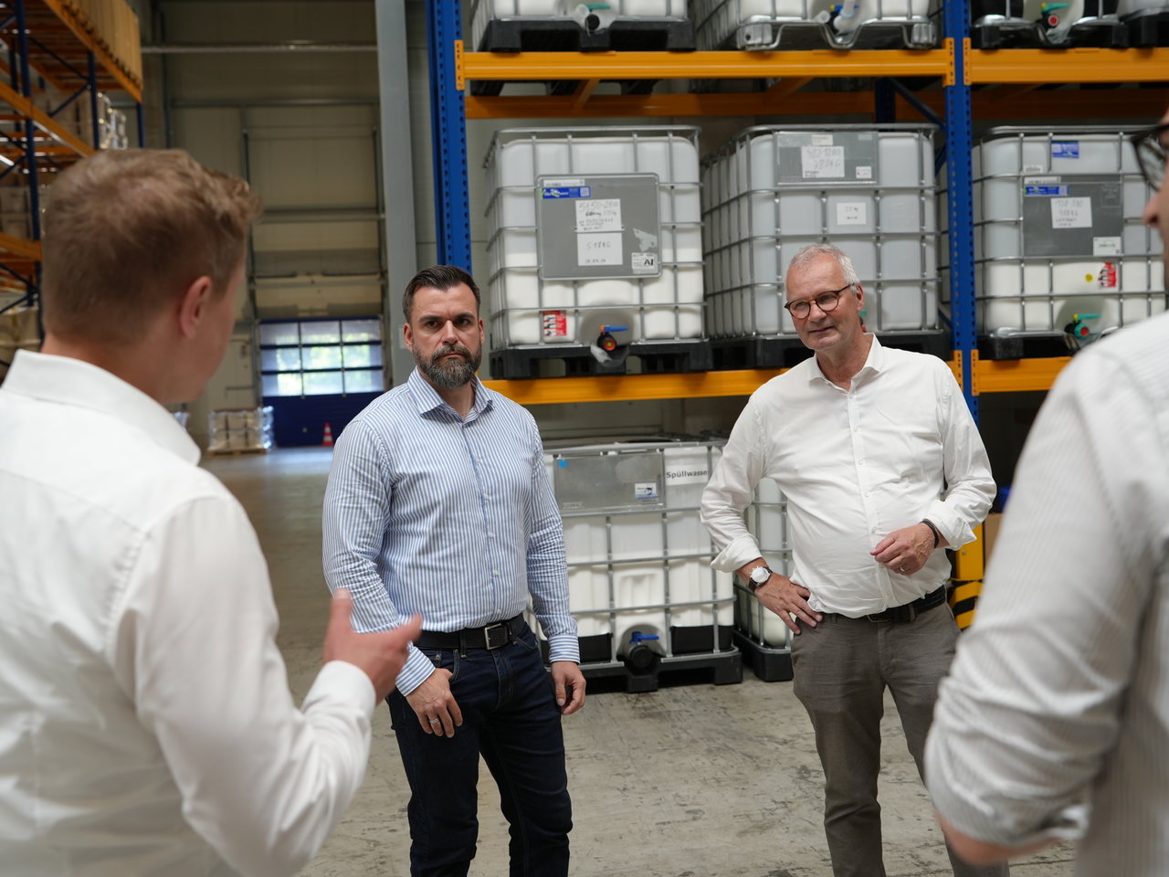 Betriebsbesichtigung im Lager der Gludan GmbH zwischen Palettenregalen