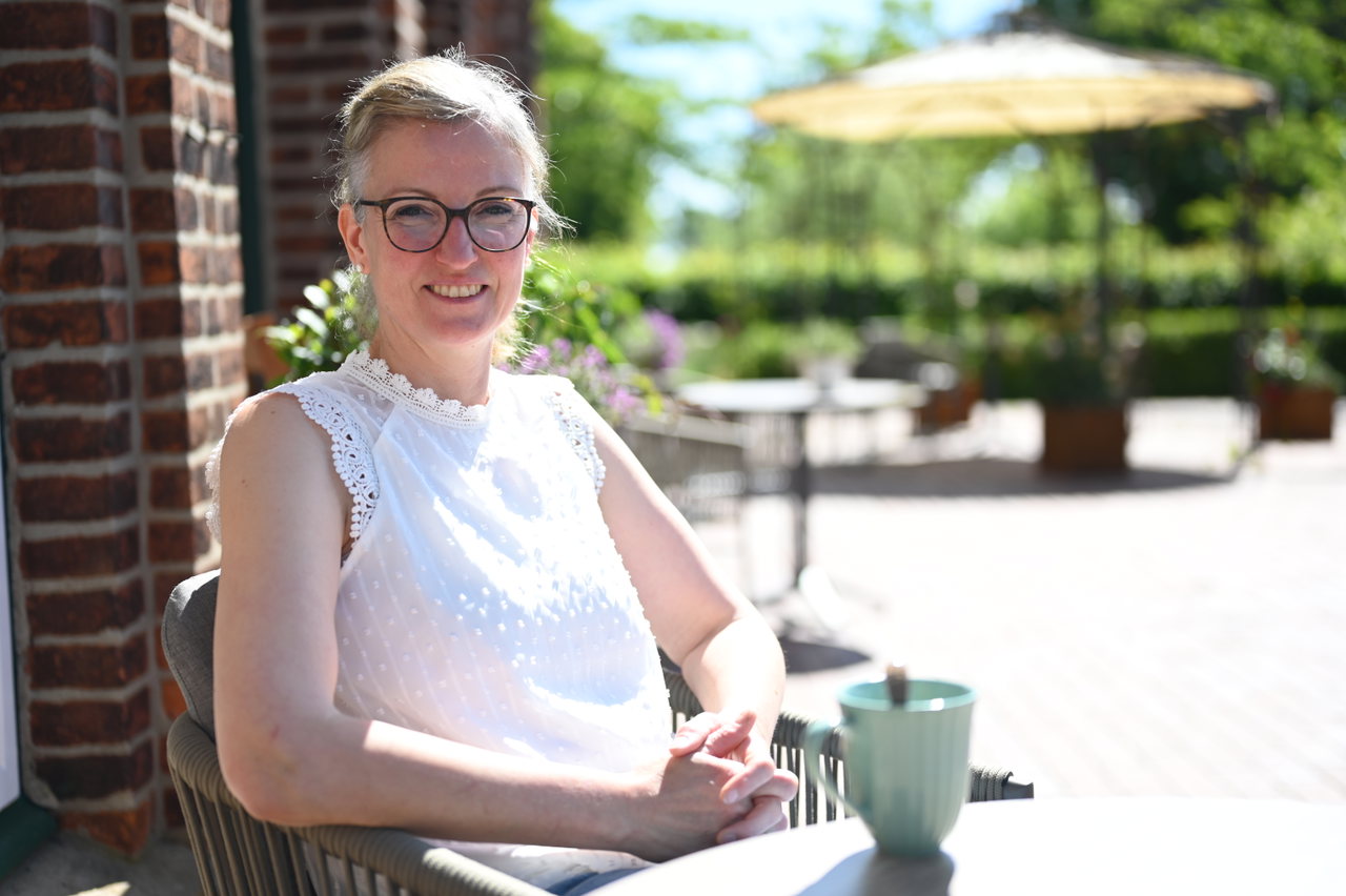 Pächterin sitzt an einem Tisch in der Außengastronomie des Cafés
