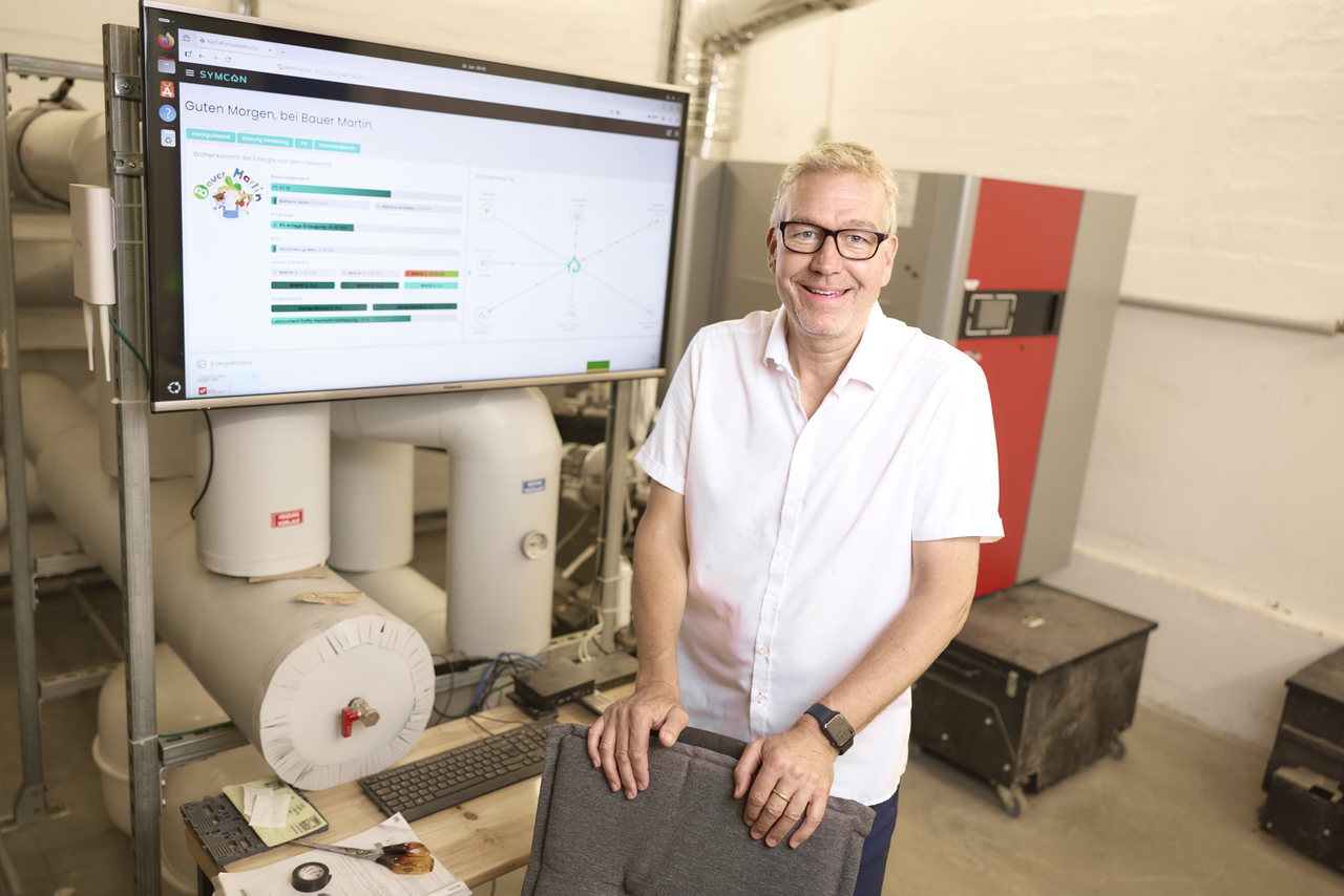 Mitarbeiterin steht vor einem großen Bildschirm mit digitalem Buchungs- und Verwaltungssystem