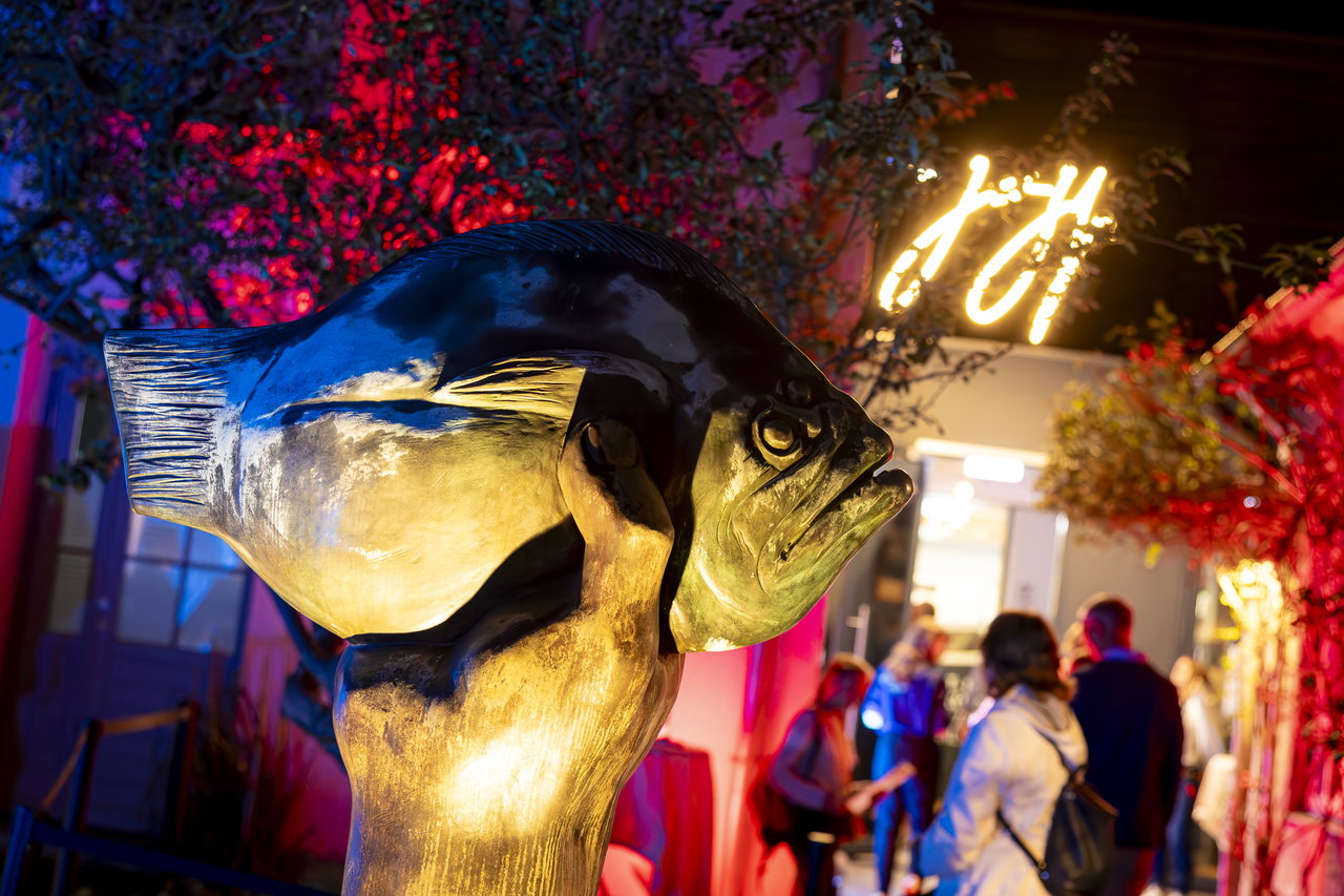 Bronzeskulptur einer Hand mit einem Butt im abendlich rot beleuchteten Skulpturenhof