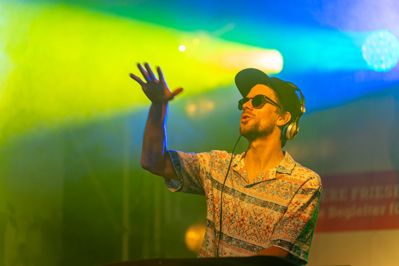 DJ FLÆK am Pult im bunten Bühnenlicht