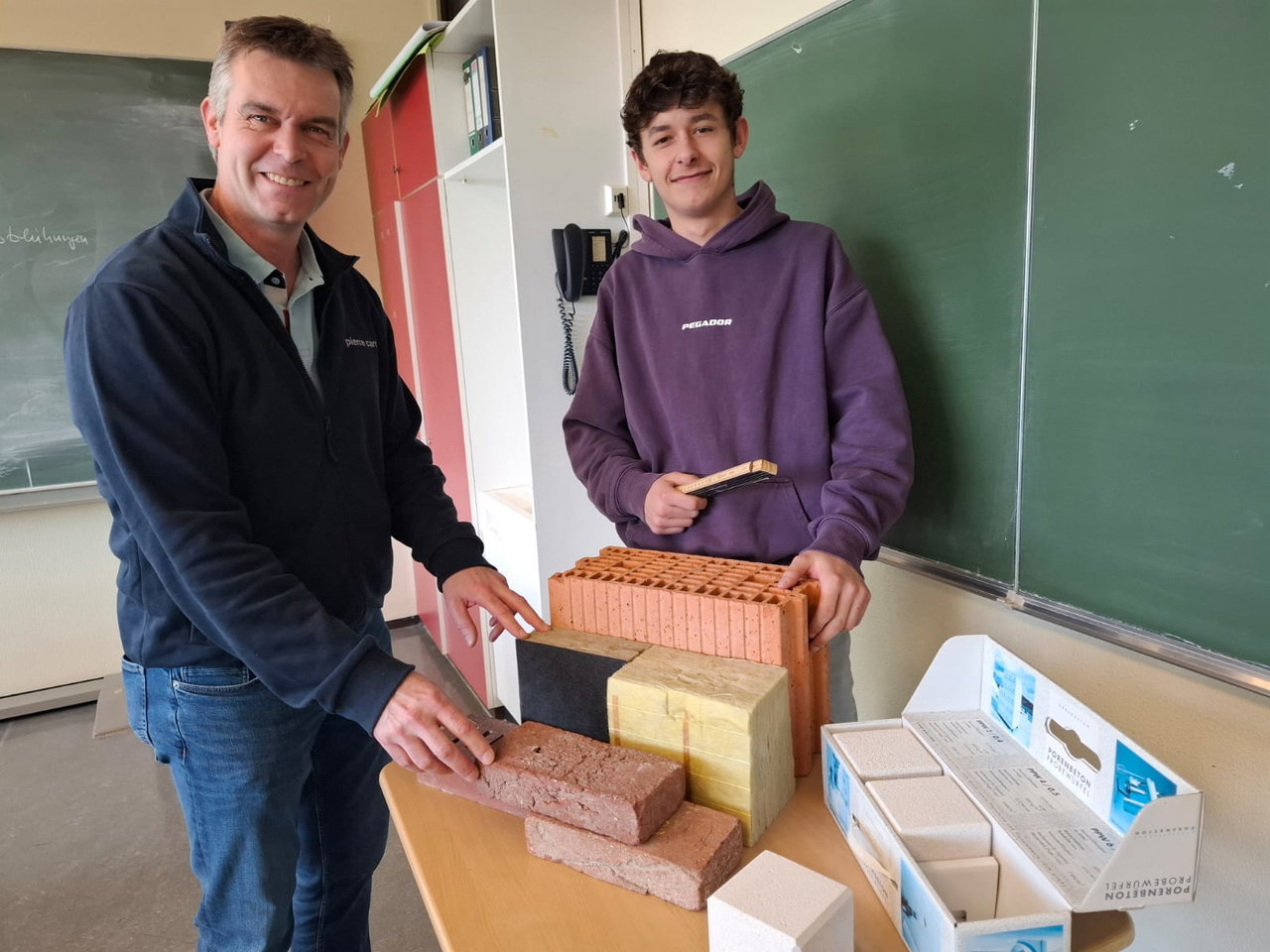 Stephan Petersen und Nico Segebrecht, der Maurer werden will. "Ich lerne jeden Tag etwas Neues!" Der Traum des Alkersumers: auf Föhr Häuser bauen.