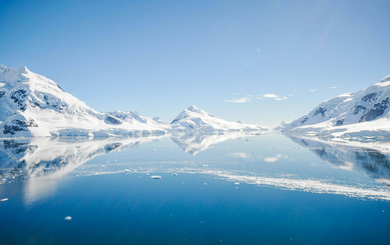 Schneebedeckte Berge spiegeln sich im stillen Wasser