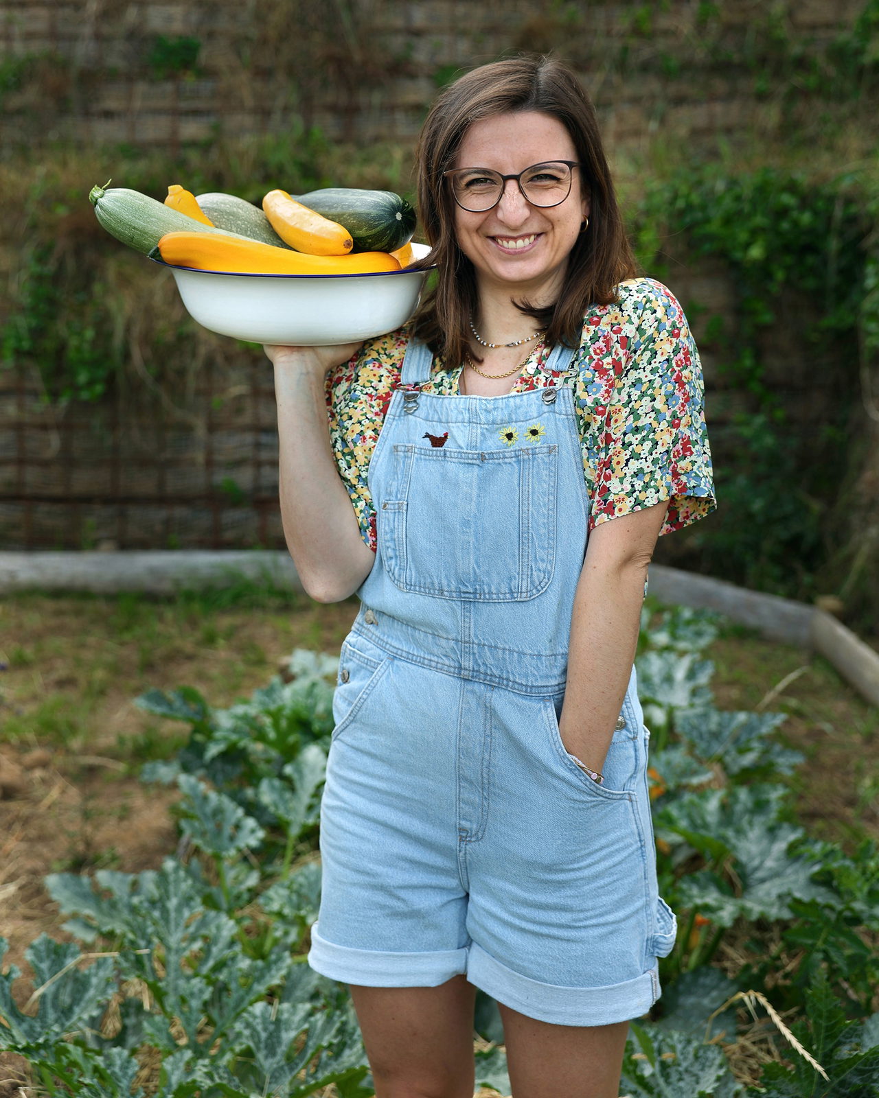 Madeleine Becker hält freudig eine Schüssel voller Zucchini