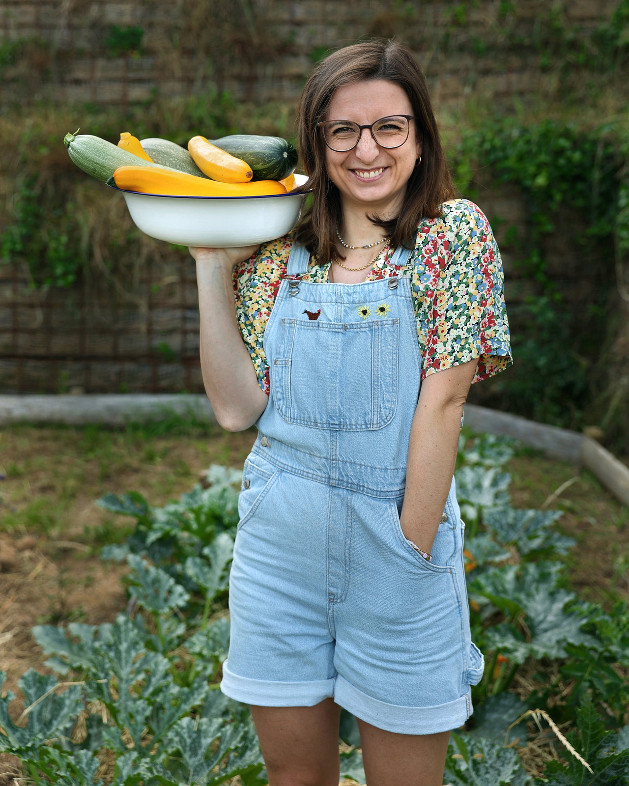 Madeleine Becker hält freudig eine Schüssel voller Zucchini