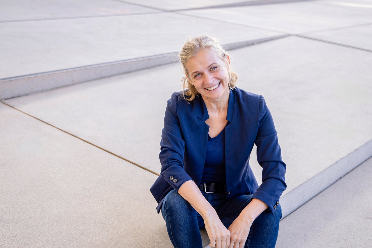 Elisabeth Staudegger sitzt auf den Stufen zur Universitätsbibliothek