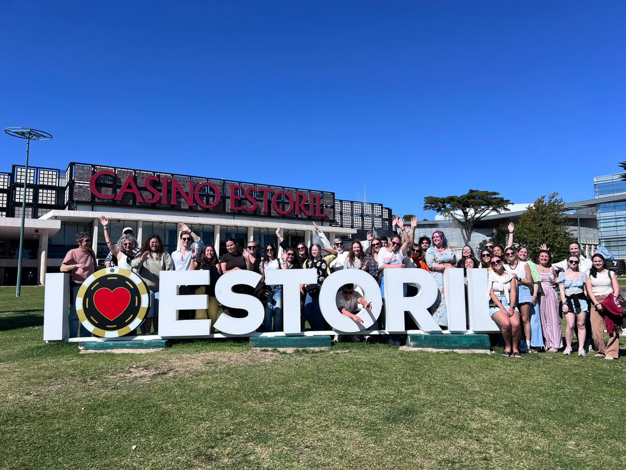 Gruppe von Studierenden und Lehrenden vor dem Schriftzug „I love Estoril“ in Portugal