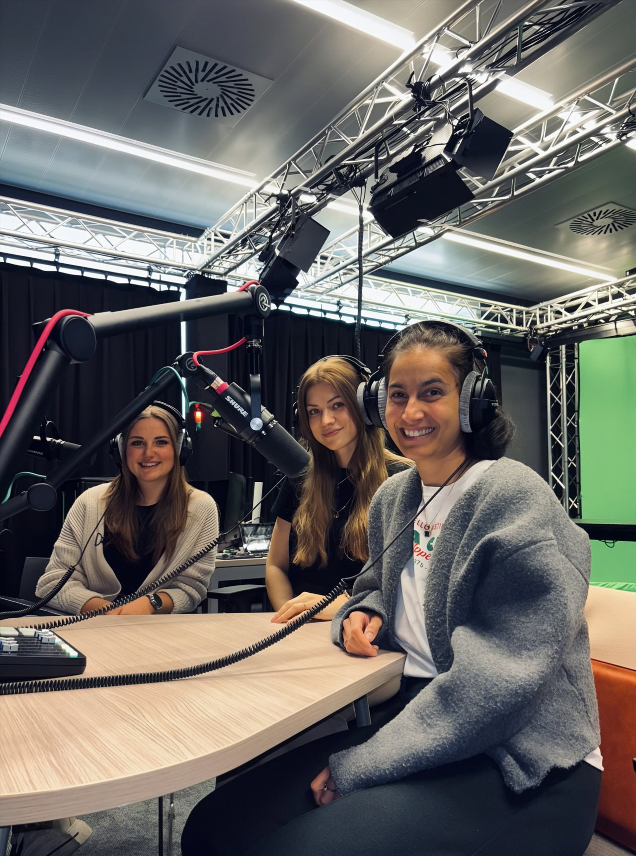 Drei Studierende mit Kopfhörern im Podcast-Studio der FH Salzburg