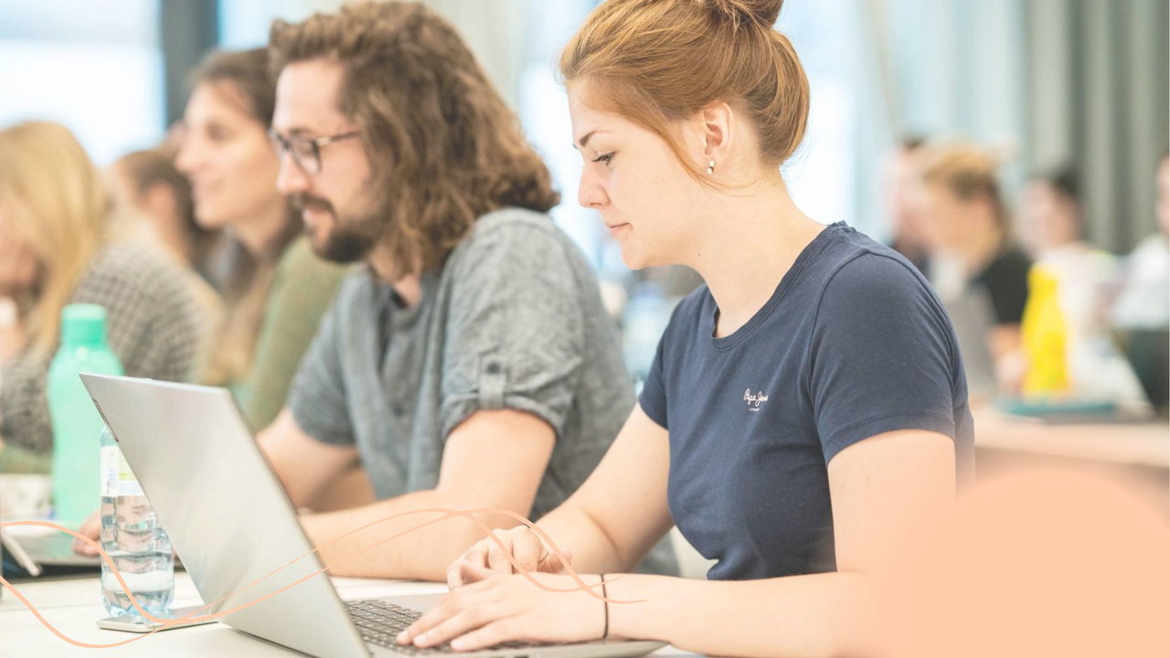 Studierende arbeiten konzentriert an Laptops in einem Seminarraum