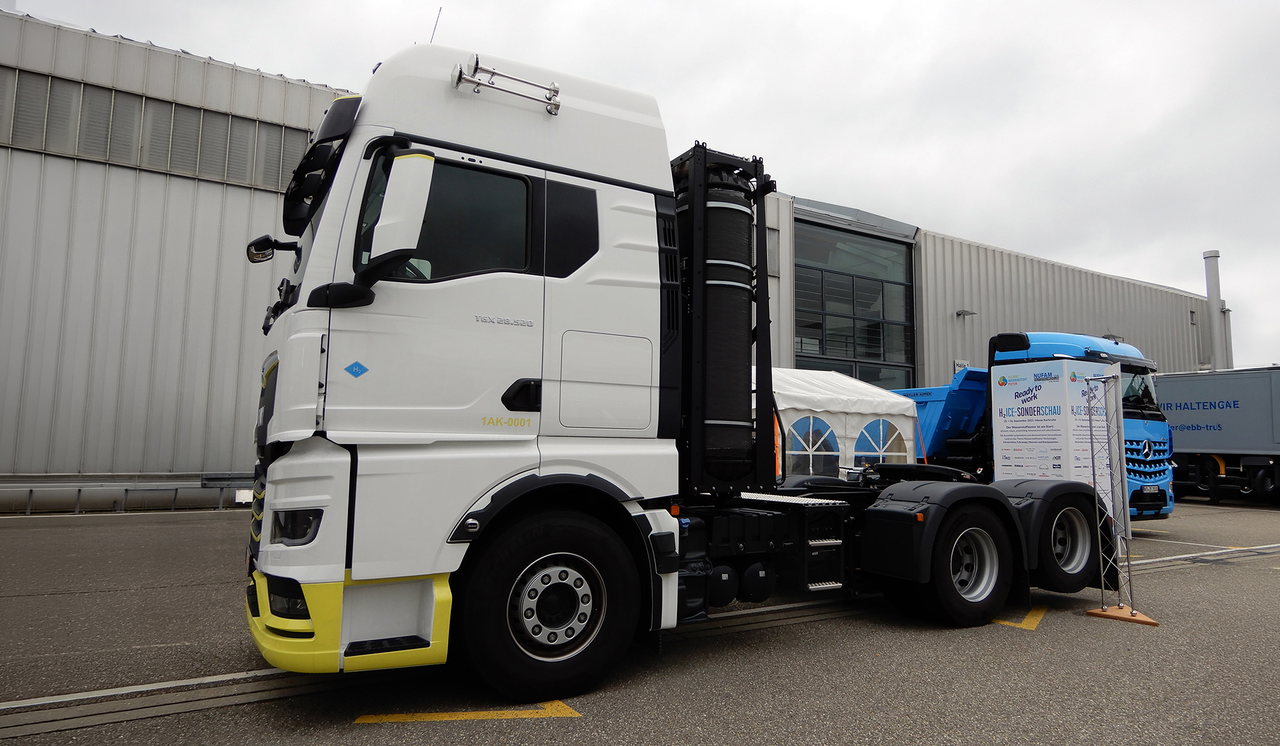 A MAN já dispõe do motor de combustão a hidrogénio no hTGX, enquanto a Daimler Truck está a testar a sua própria versão no semirreboque basculante Arocs azul à direita.