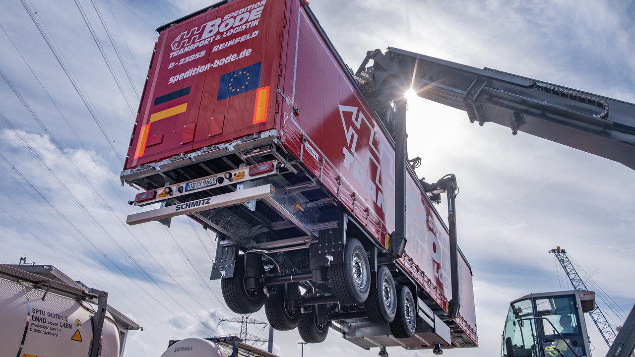 Millimeterarbeit am CTL in Lübeck: Ein Reach Stacker hebt den Sattelcurtainsider S.CS von Schmitz Cargobull auf den Waggon.