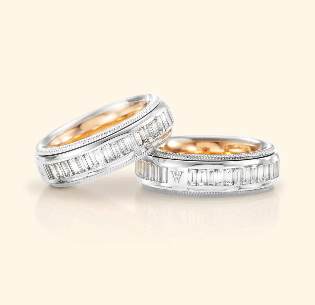 Zwei Wellendorff Ringe BAGUETTE-ZAUBER aus Weißgold mit Diamanten im Baguetteschliff und goldener Innenseite liegen nebeneinander.