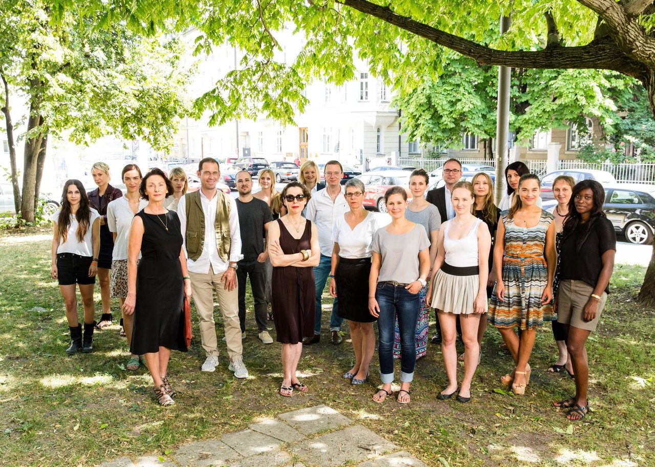 Gruppenfoto des storyboard-Teams unter großen Bäumen vor einem Altbau