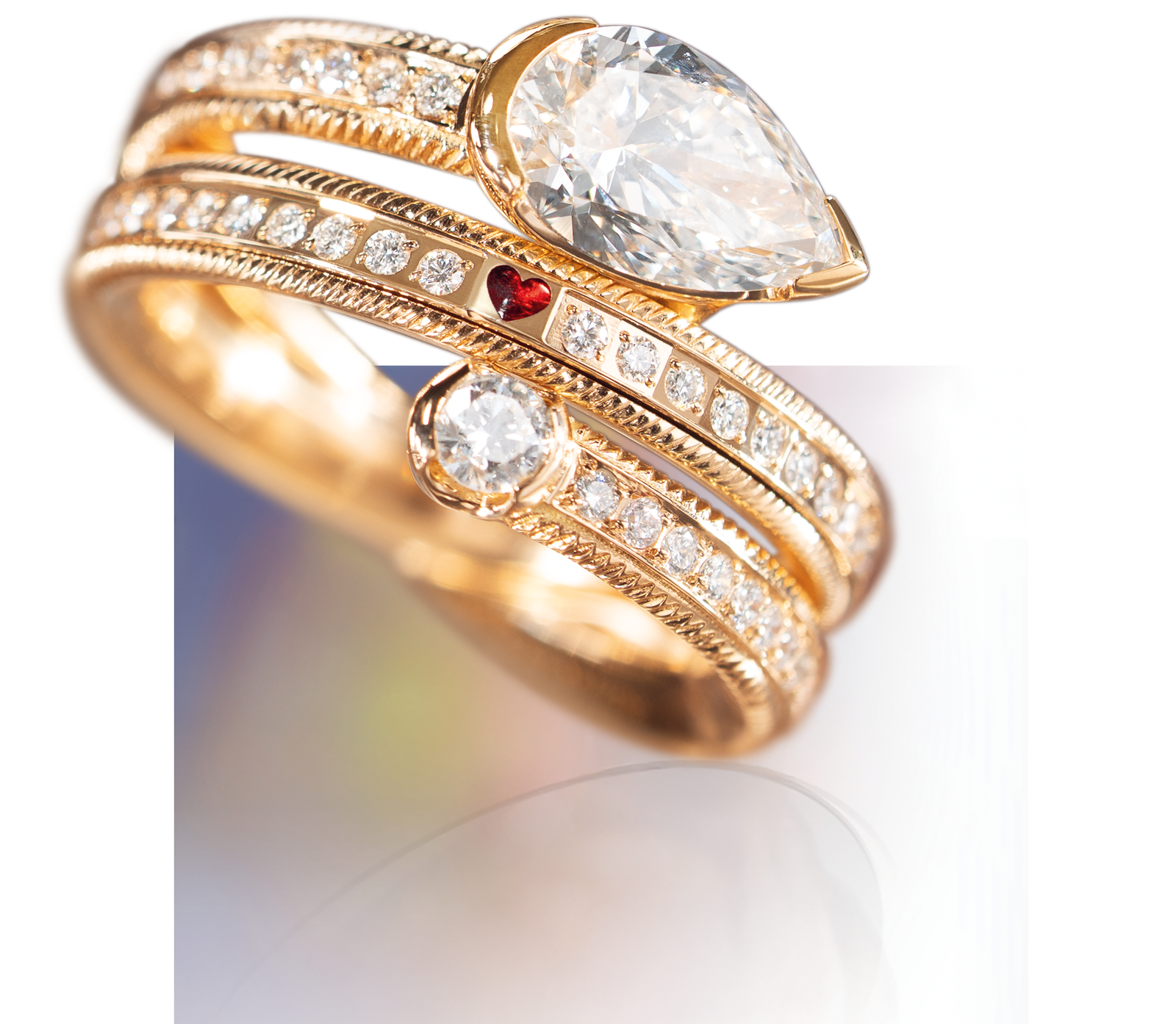 Detailansicht des Wellendorff Rings DIAMANTTROPFEN besetzt mit kleinen Diamanten, einem tropfenförmigen und einem runden Hauptdiamanten sowie einem kleinem roten Akzentstein in Herzform