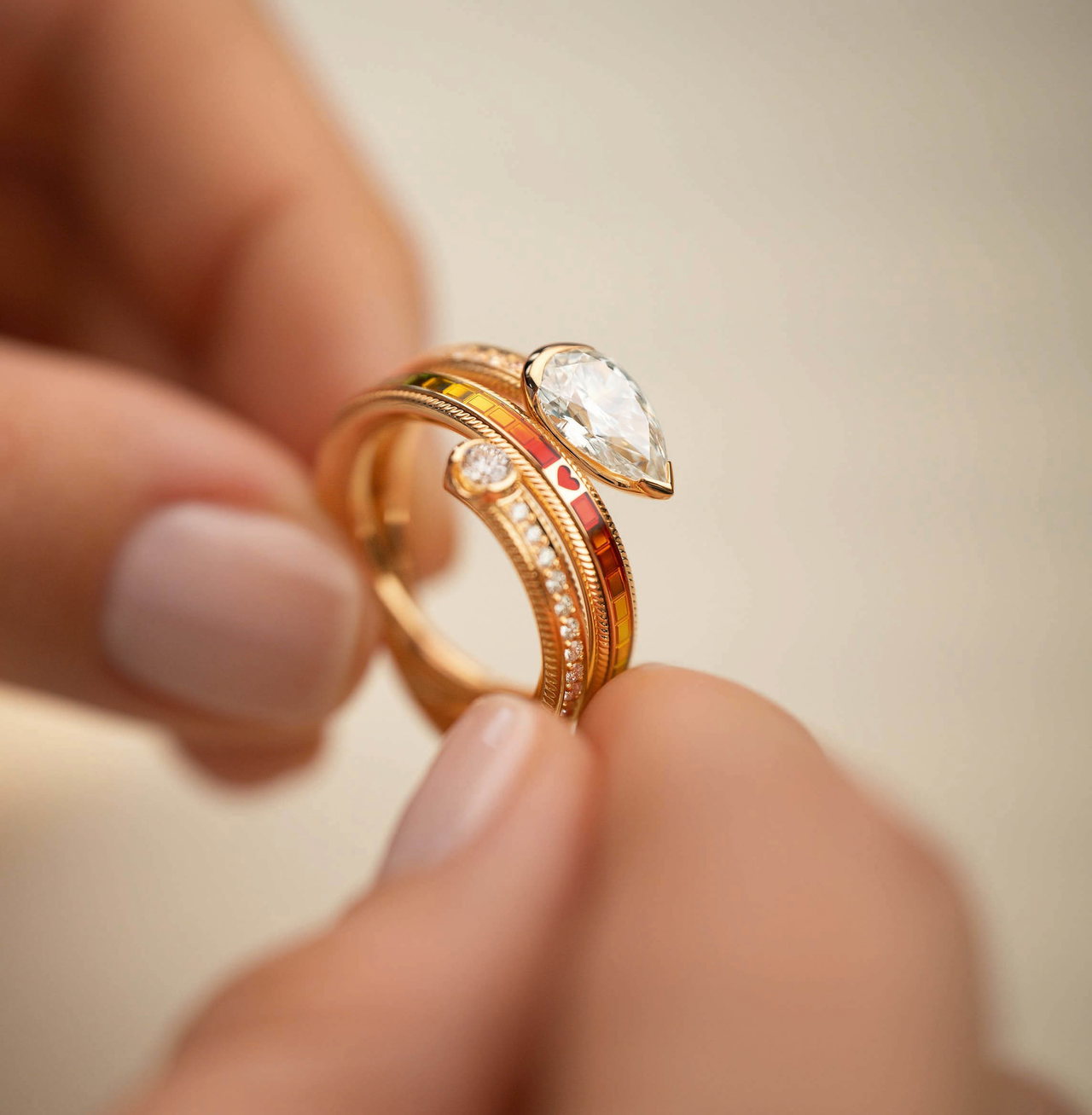 Nahaufnahme des Wellendorff-Rings DIAMANTTROPFEN mit farbig emmailliertem Glücksring, der von zwei Händen gehalten wird