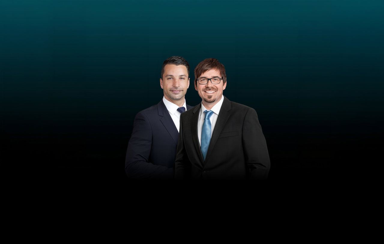 Zwei Freisteller vor dunklem Hintergrund, links ist Markus Haindl abgebildet und rechts Ralf Heisig. Beide Männer tragen einen Anzug. 