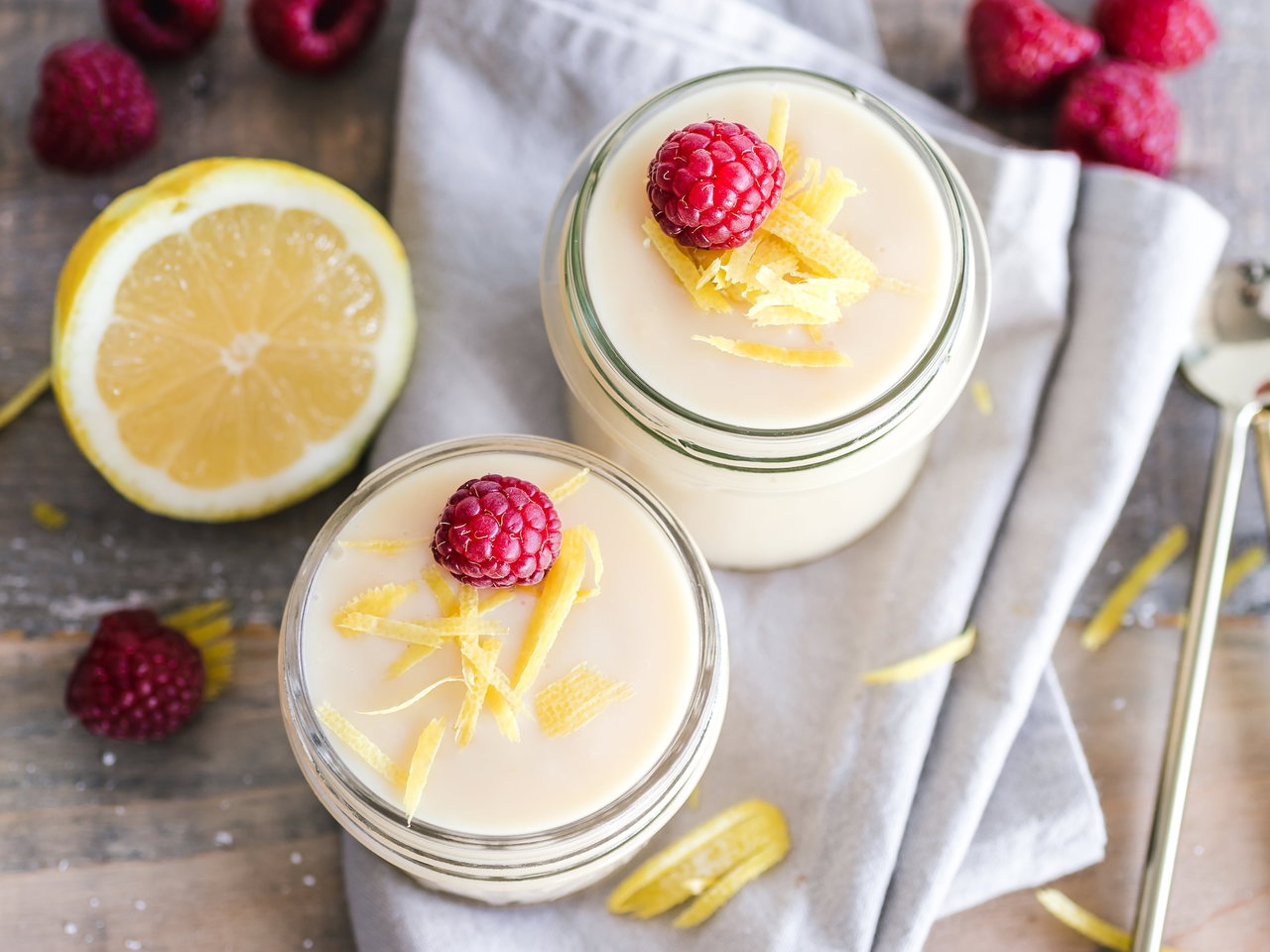 Zitronenküchlein im Glas mit Himbeeren und Zitronenzesten