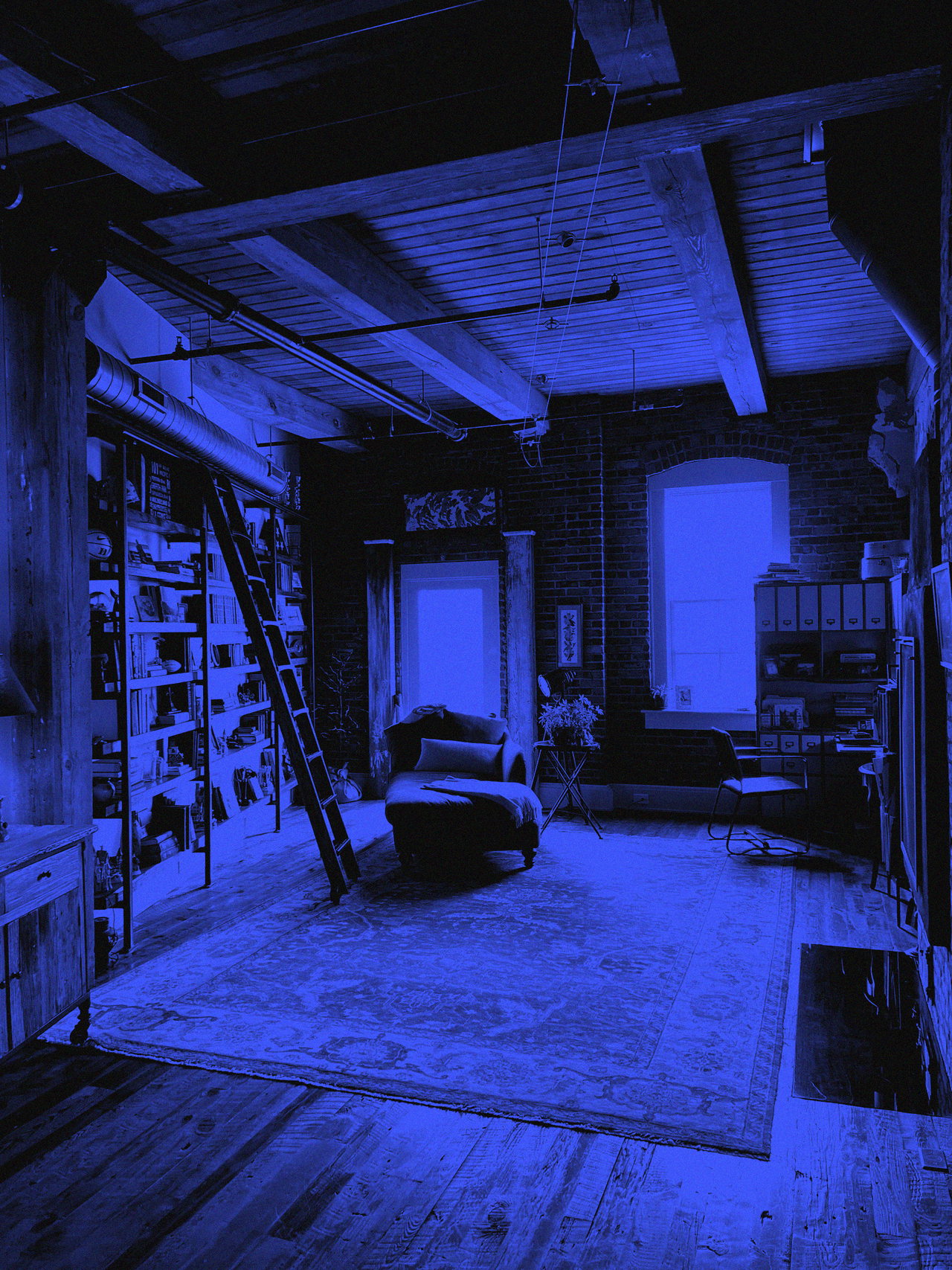 Gemütliches Backstein-Loft mit Bücherregal, Leiter, Sessel und Holzbalkendecke (Duplex in Schwarz und Blau)