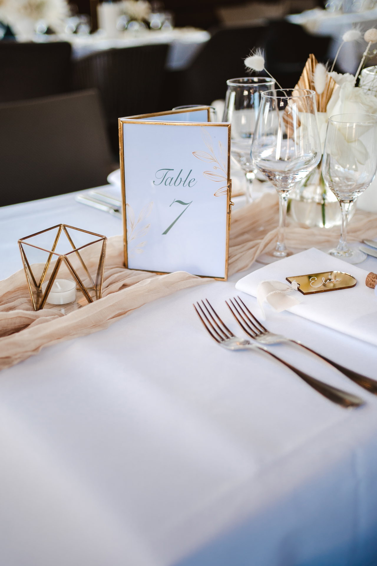 Tischnummer in einem goldenen Rahmen auf weißer Decke