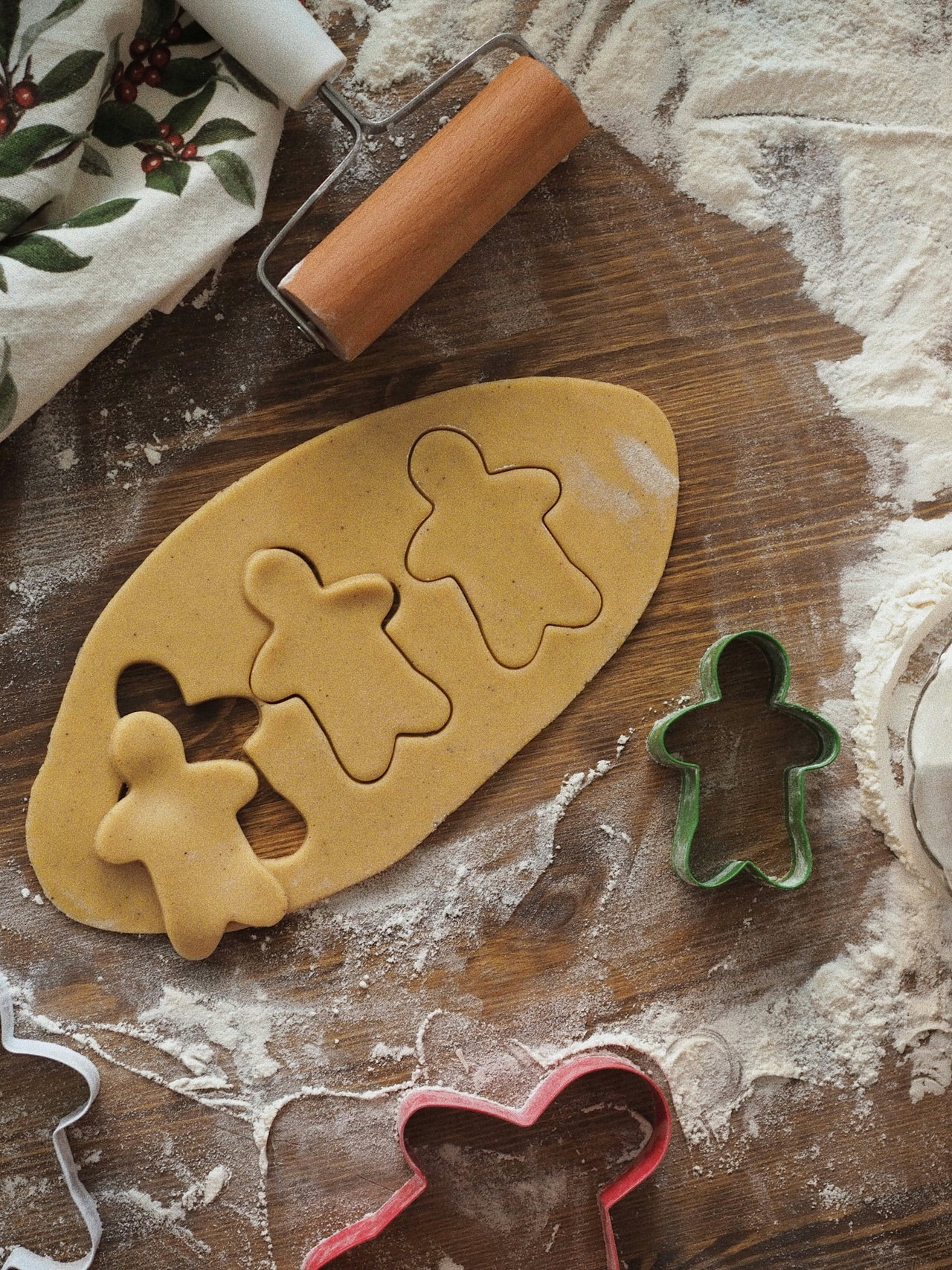 Ausgerollter Mürbeteig mit ausgestochenen Lebkuchenmännchen, daneben Ausstecher und ein Nudelholz