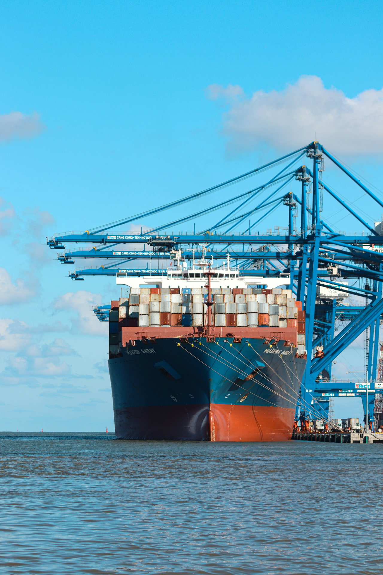 Containerschiff im Hafen mit Kränen