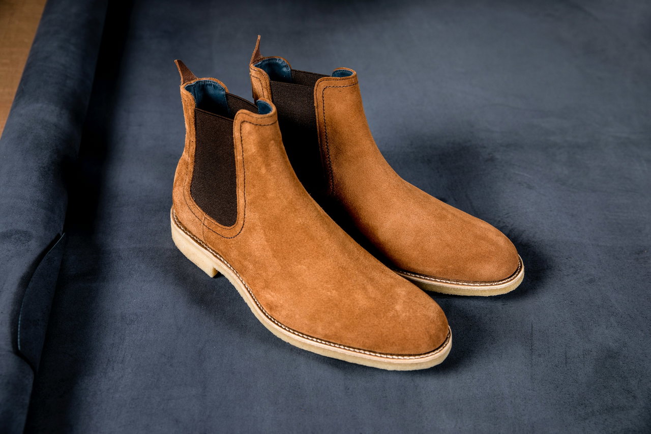 Paar Chelsea-Boots aus Veloursleder in Tabak auf dunkelblauem Samt