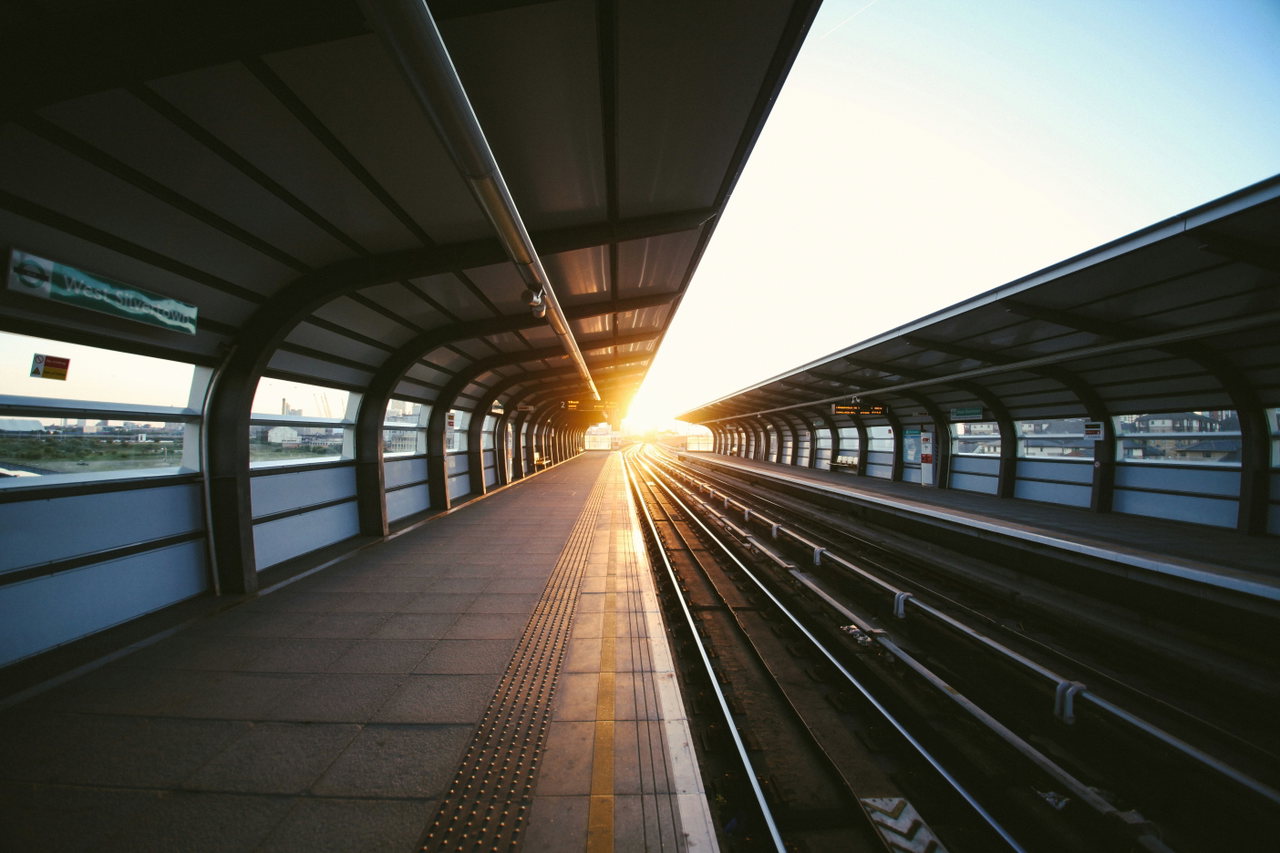 Überdachter S-Bahnsteig im Gegenlicht, die Sonne steht am Ende der Gleise