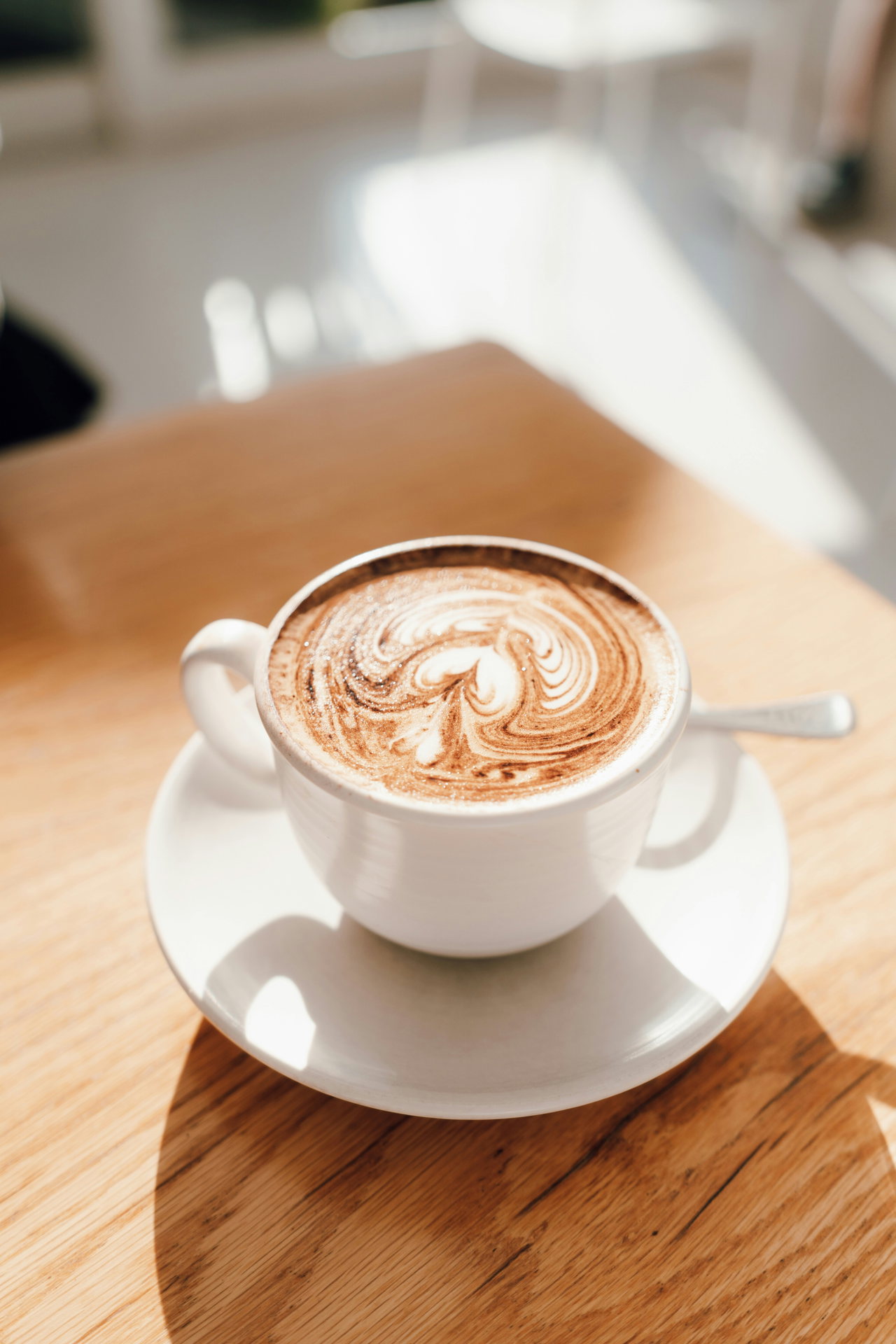 Cappuccino mit Latte Art auf Holztisch