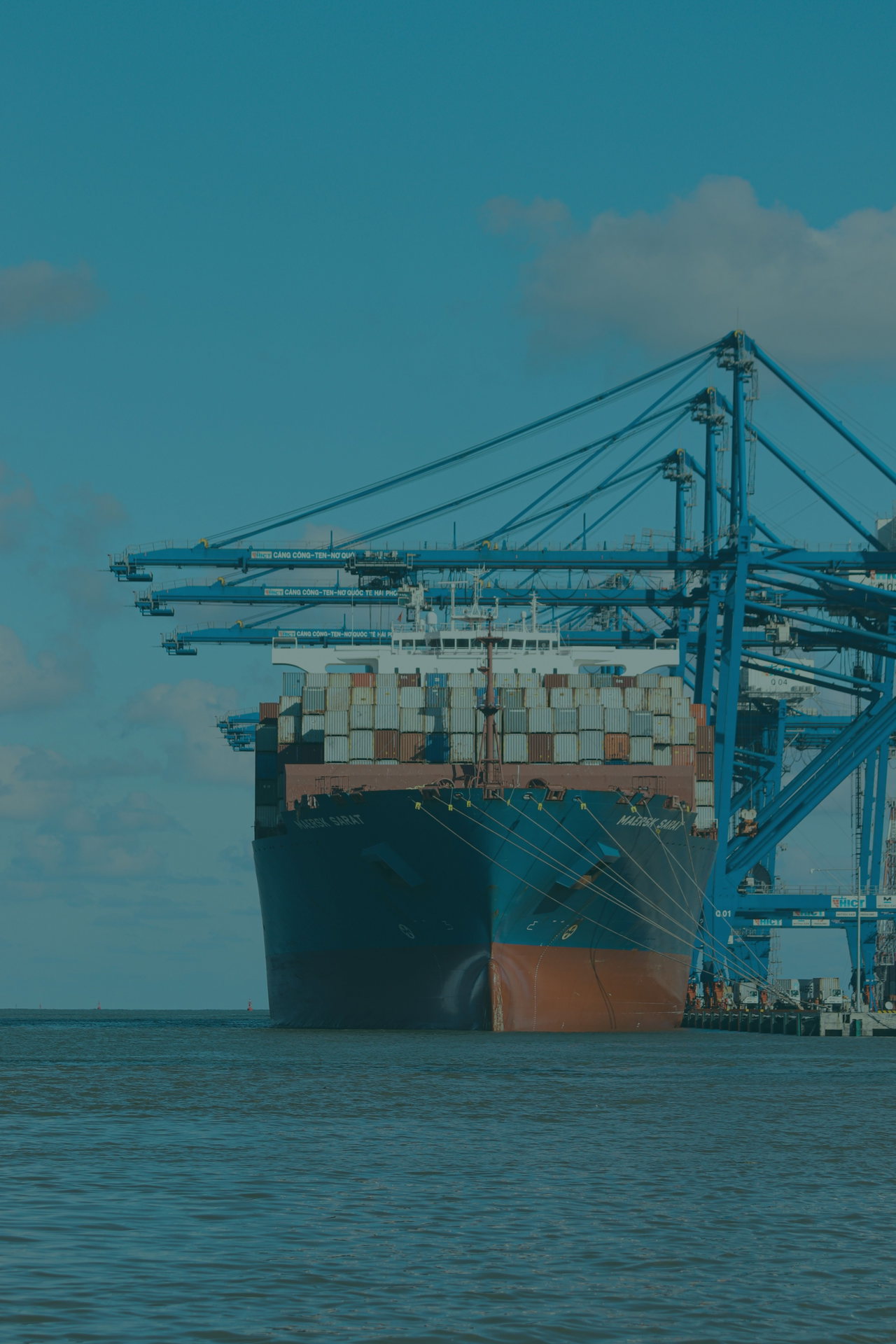 Containerschiff im Hafen mit Kränen
