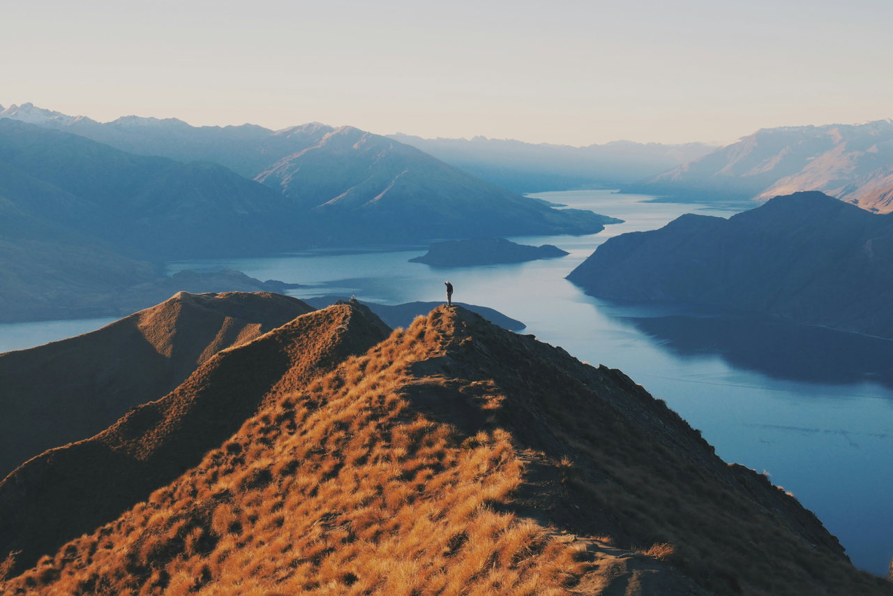 Wanderer auf einem Bergrücken über einem See in Neuseeland