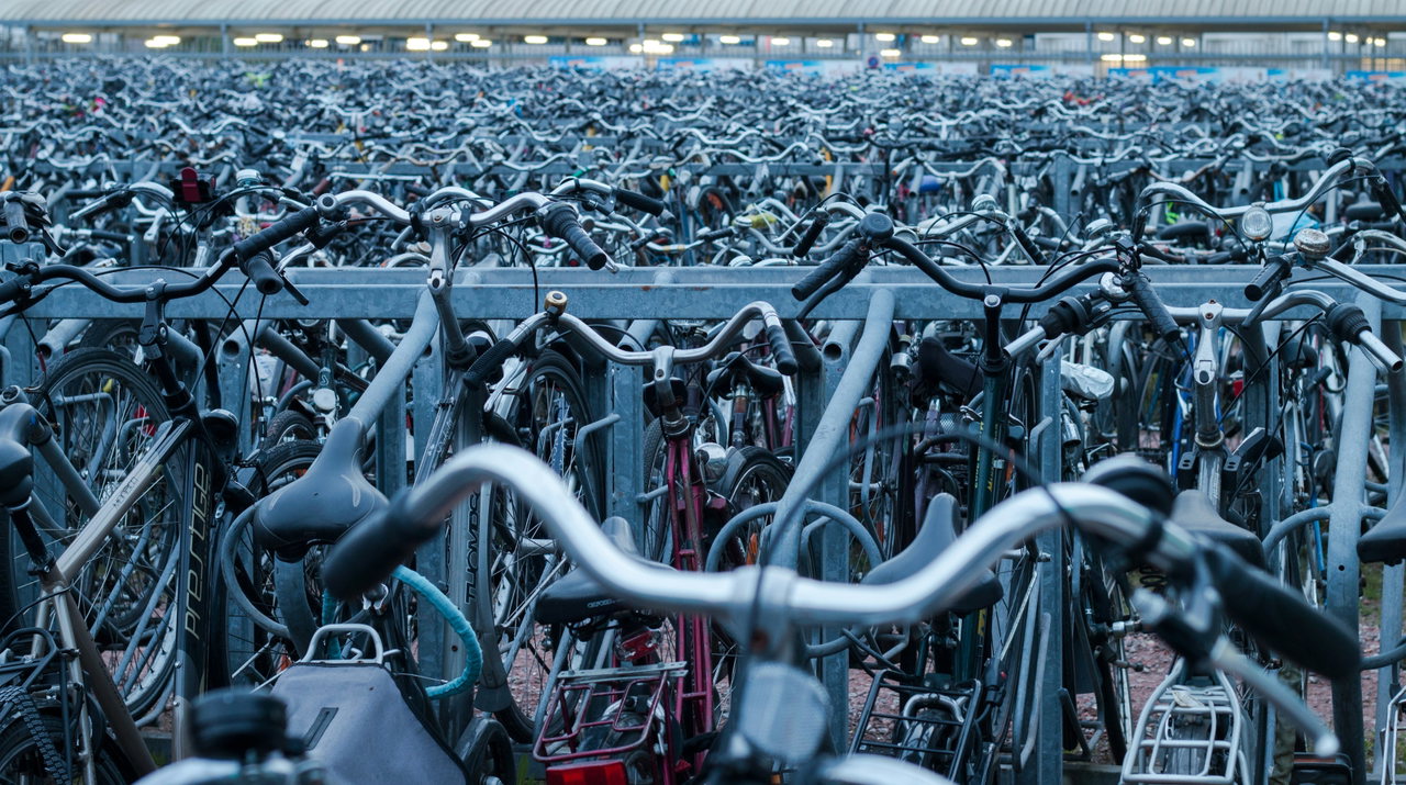 Huge bicycle park with countless bicycles parked in several rows