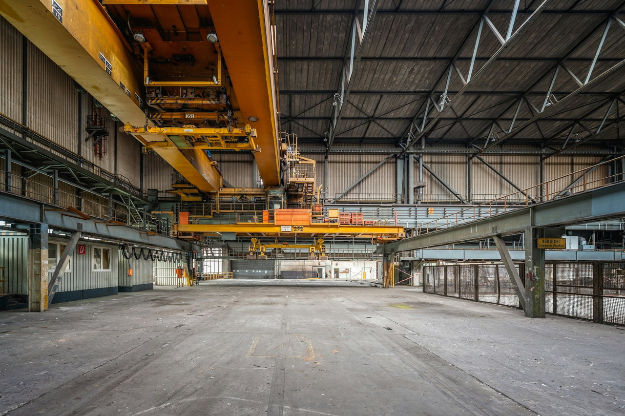 Industriehalle mit Mitarbeitenden an Maschinen