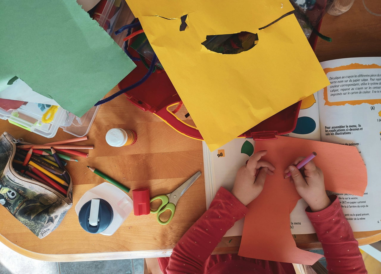 Kinderhände schneiden buntes Papier