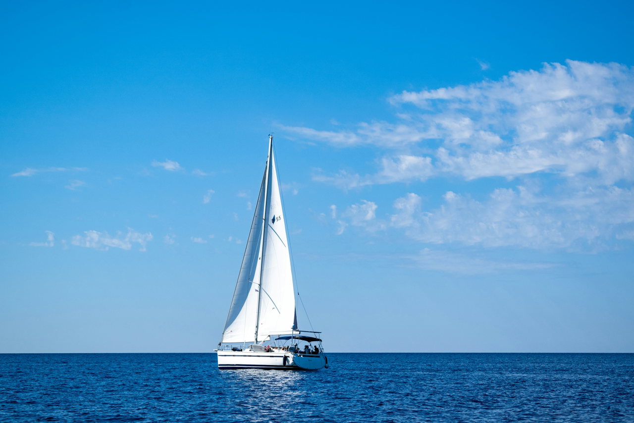 Segelboot auf offener See unter blauem Himmel