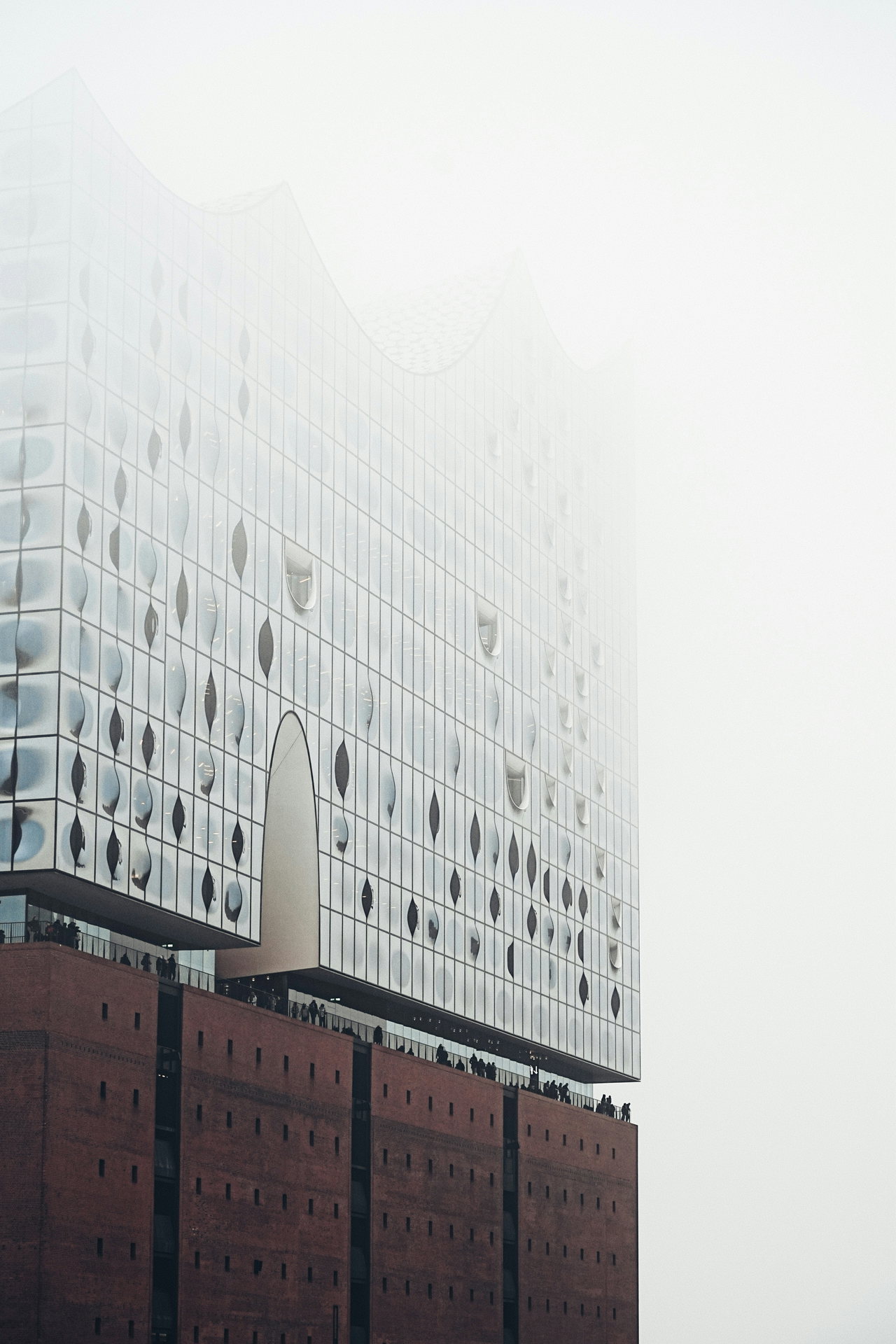 Die Elbphilharmonie über dem Backsteinsockel im Nebel