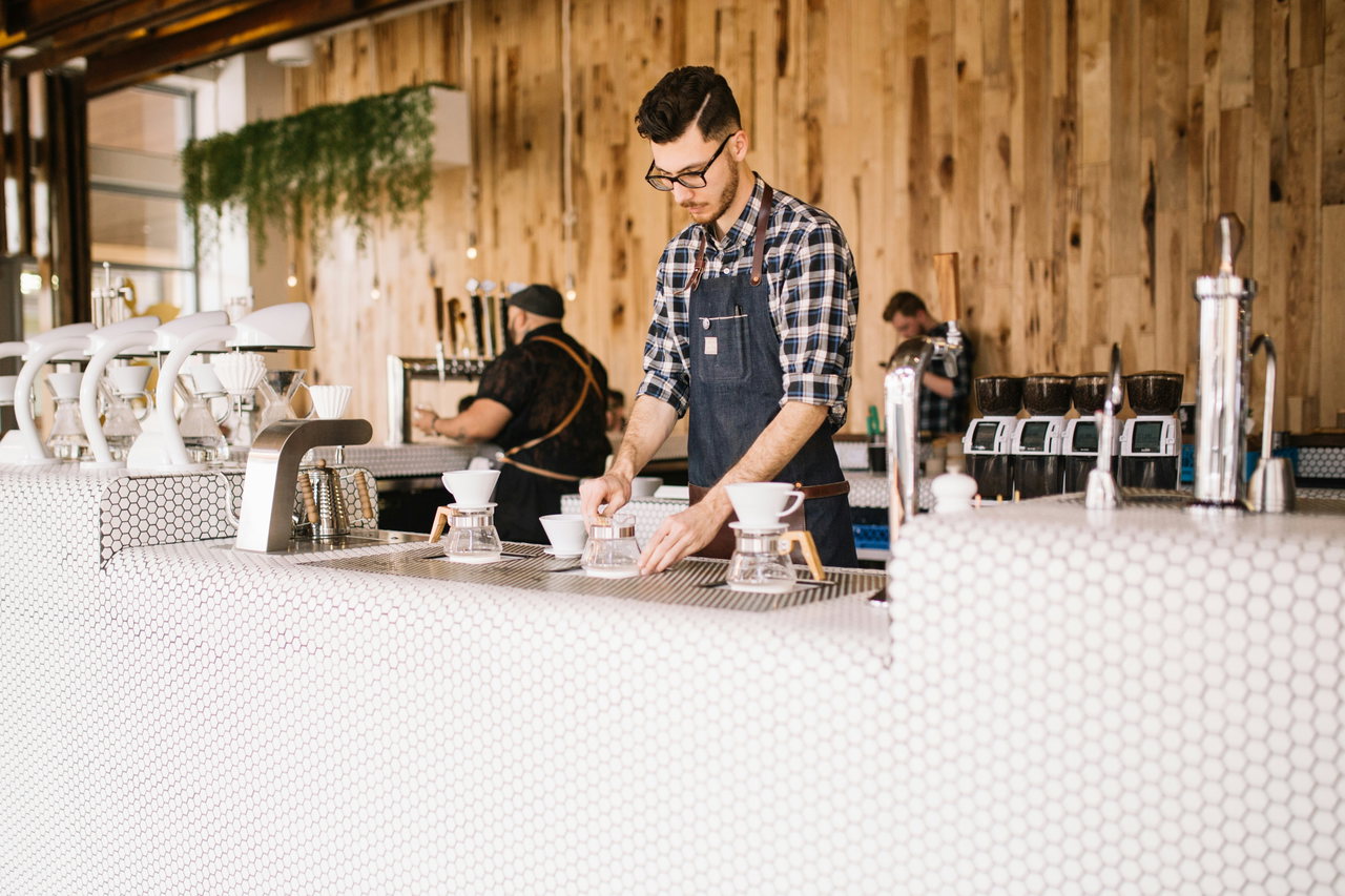 Zwei Baristas hinter dem weißen Tresen