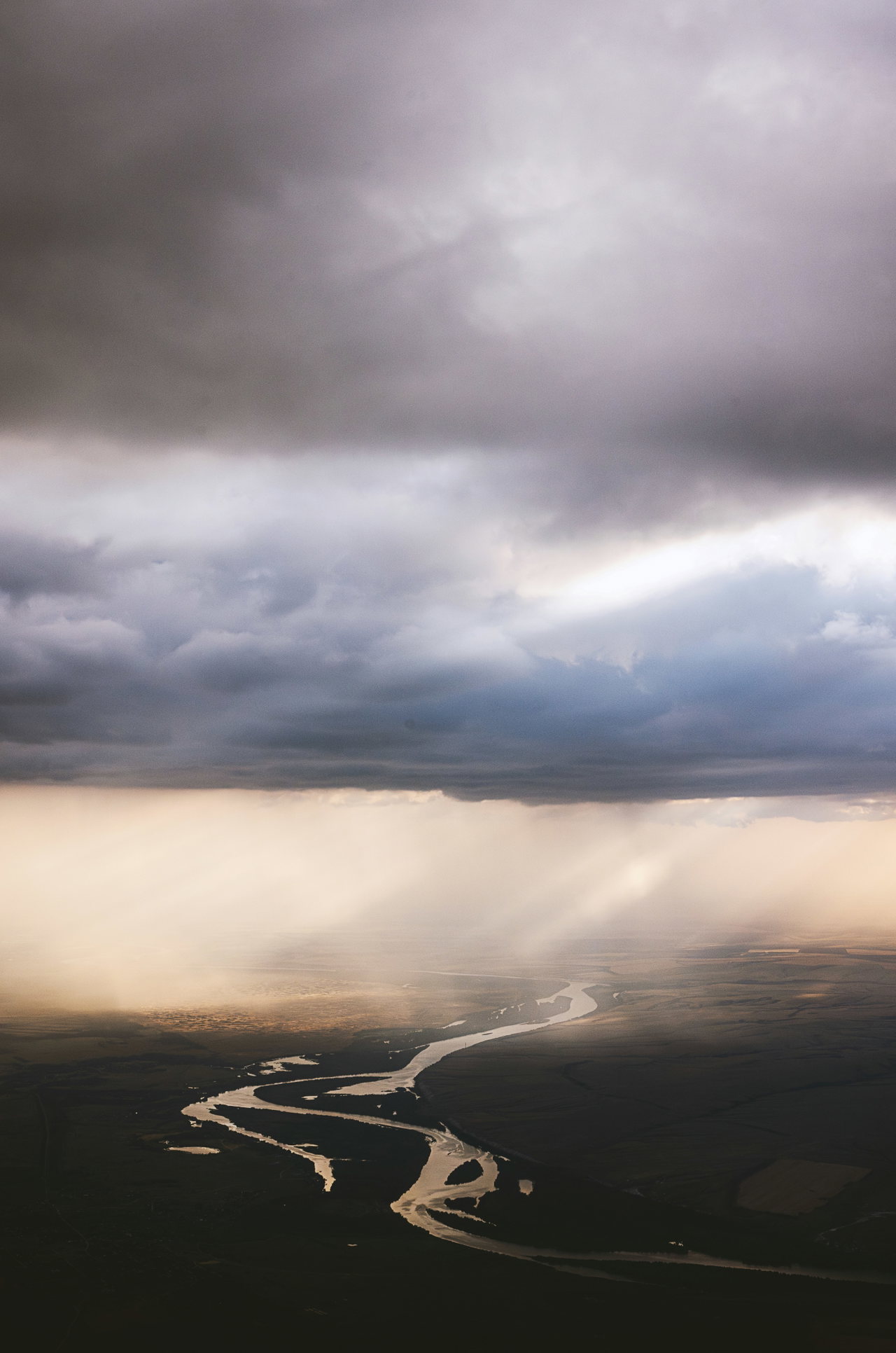 Flusslauf aus der Luft unter dunklen Wolken