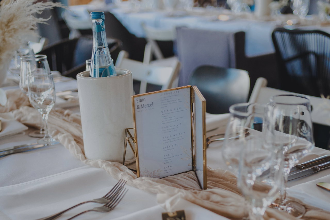 Gedeckter Tisch mit Menükarte im goldenen Rahmen