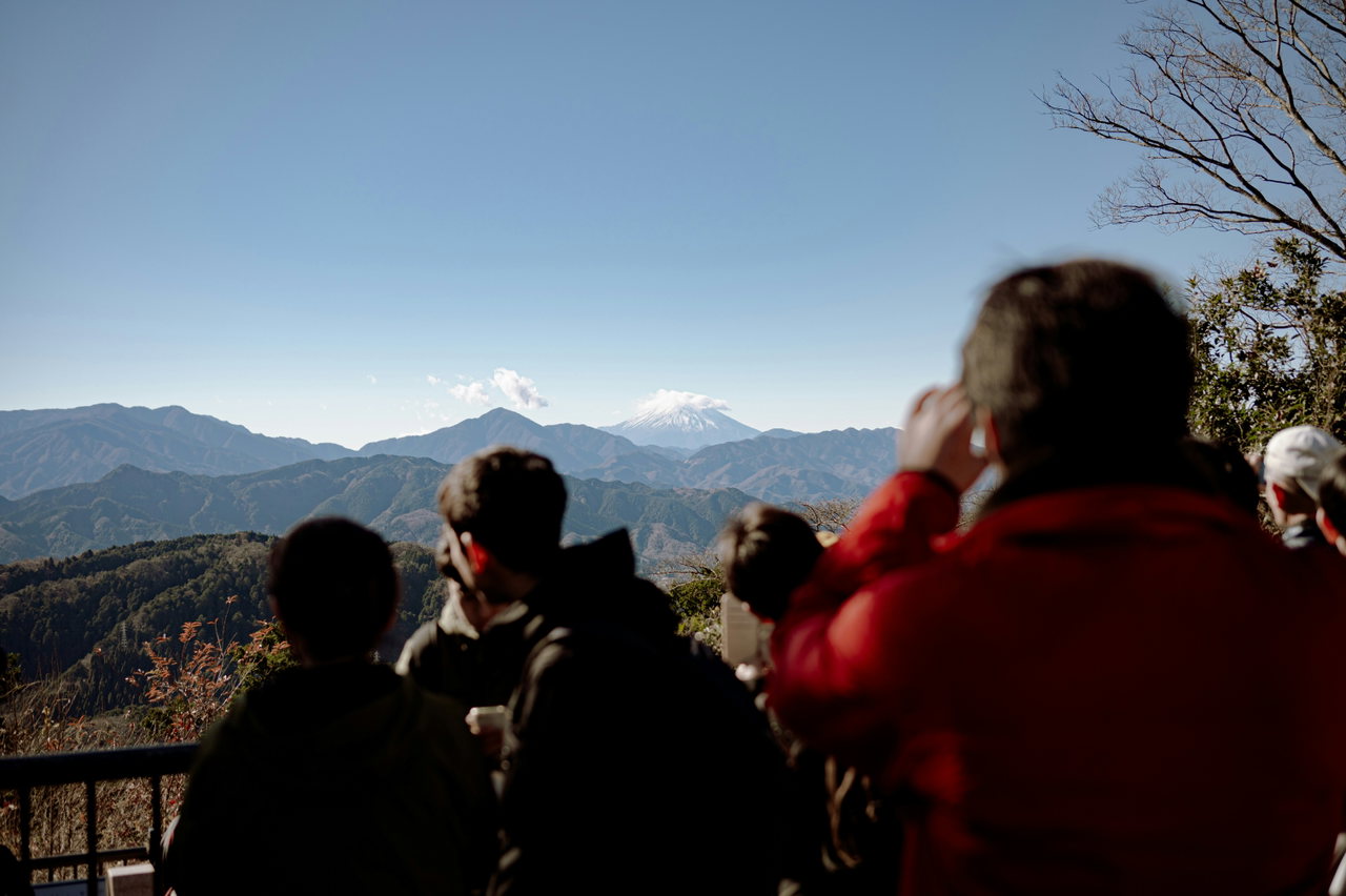 Menschen an einem Aussichtspunkt blicken auf den Fuji